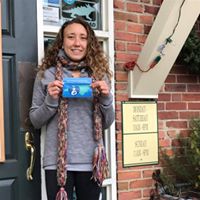 Townsend Bertram and Company employee holding "Breastfeeding Welcome Here" sign in front of door