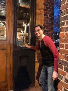Spotted Dog Restaurant employee pointing to Breastfeeding Welcome Here cling on the window next to the door